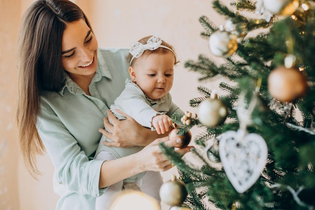 Free Photo | Mother with baby daughter dacorating christmas tree