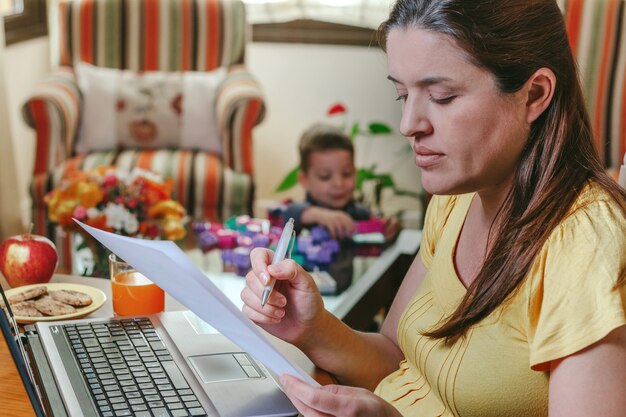 Premium Photo Mother Working On The Laptop In The Living Room While