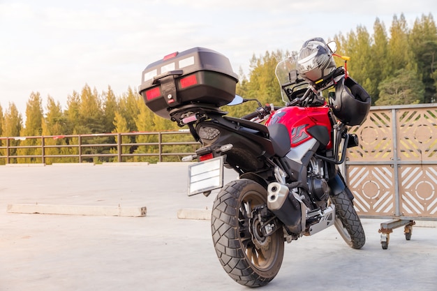 Motorcycle gloves and safety helmet hanging on a front seat of sport motorbike for safety Premium Photo