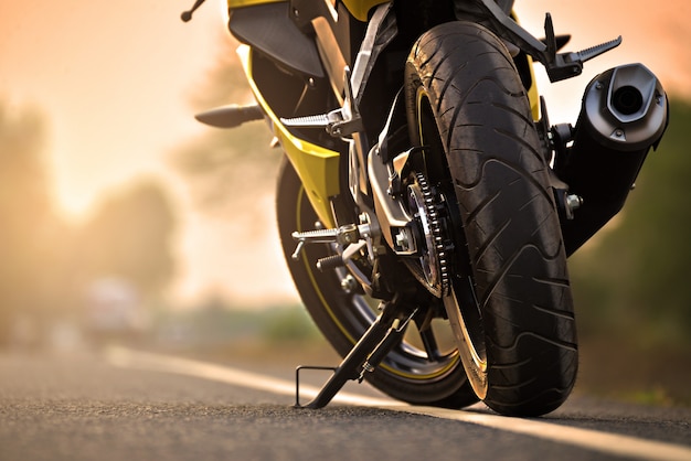 A motorcycle parking on the road right side and sunset Premium Photo