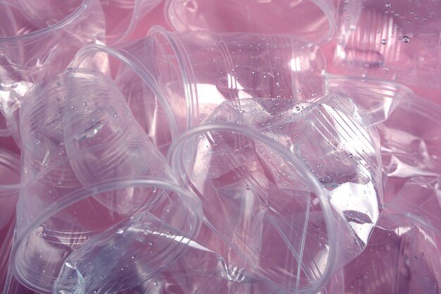 Premium Photo | A mountain of garbage from plastic cups on pink background