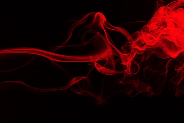 Movement of red smoke on black background. fire design ...
