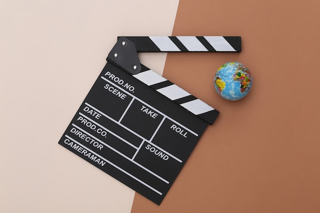 Premium Photo | Movie clapper board and globe on beige brown background ...