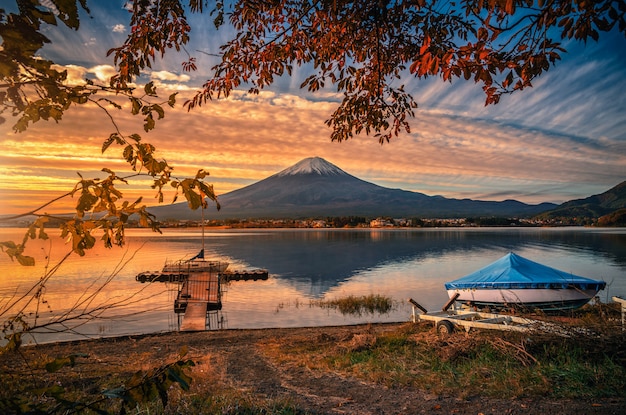山秋の紅葉と富士河口湖の日の出でボートで川口湖の上の富士 プレミアム写真