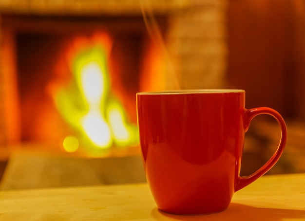 Premium Photo | Mug for tea or coffee , on background of cozy fireplace ...