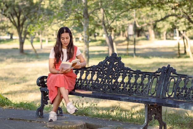 Premium Photo Mujer Latina Sentada En Una Banca De Un Parque Leyendo