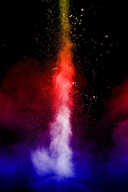 黒い背景に複数の色の粒子の爆発 暗い背景に色とりどりの埃が飛び散る プレミアム写真