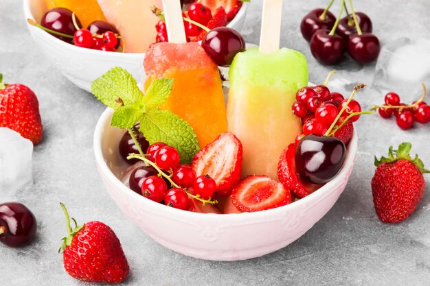 Premium Photo | Multi-colored popsicles with strawberry, red currant ...