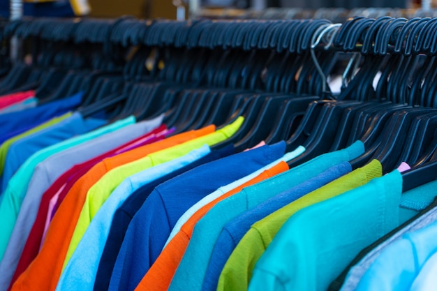 Premium Photo | Multi-colored t-shirts on a hanger. clothing store