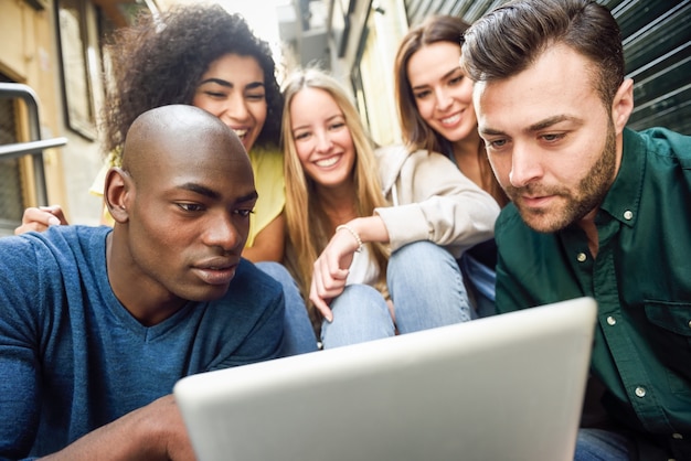 Multi-ethnic group of young people looking at a tablet computer Photo ...