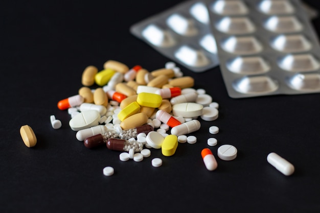Multicolored different pills with two grey shine blisters Premium Photo