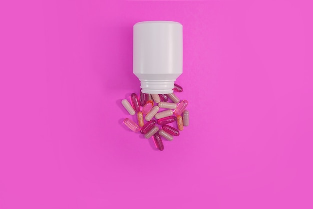 Premium Photo | Multicolored pills and capsules on a pink background