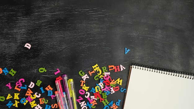Multicolored small wooden letters of the english alphabet and paper notebook Premium Photo
