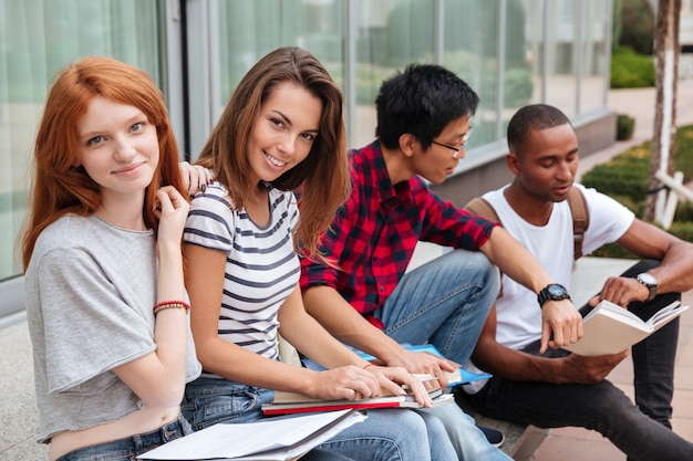 Premium Photo | Multiethnic group of happy young students sitting and ...