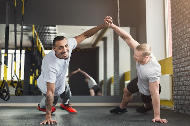 Premium Photo | Multiethnic happy men workout in fitness club. cheerful ...