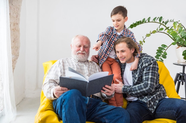 Multigenerational men watching album Free Photo