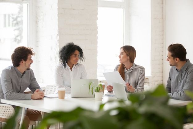 Multiracial male and female colleagues having discussion at team meeting Free Photo