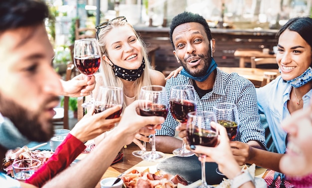 Premium Photo | Multiracial people toasting wine at restaurant garden ...