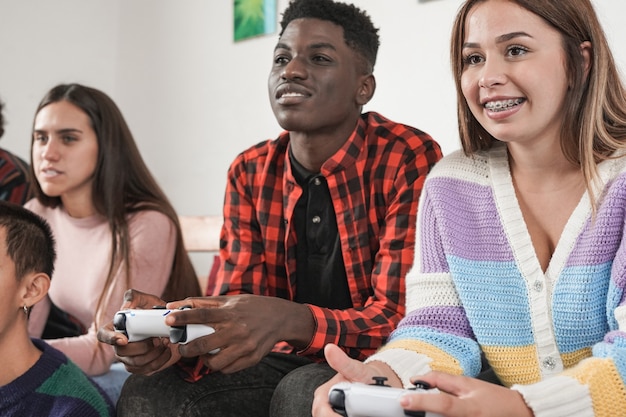 Premium Photo | Multiracial young people playing video games at home ...