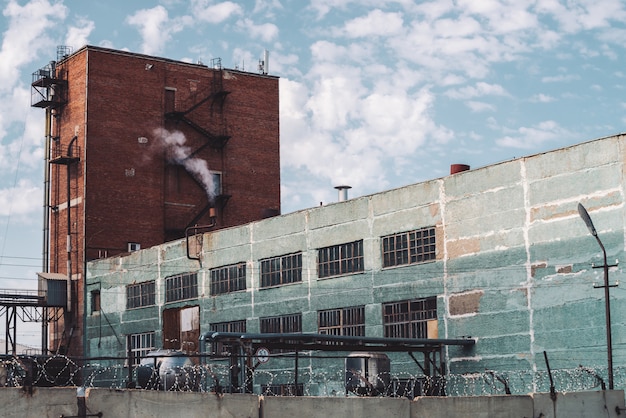 Premium Photo Multistory Production Building Behind Fence With Barbed