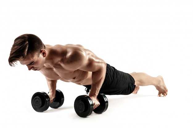 Premium Photo | Muscular bodybuilder guy doing push-ups on dumbbells