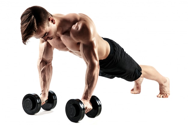 Premium Photo | Muscular bodybuilder guy doing push-ups on dumbbells