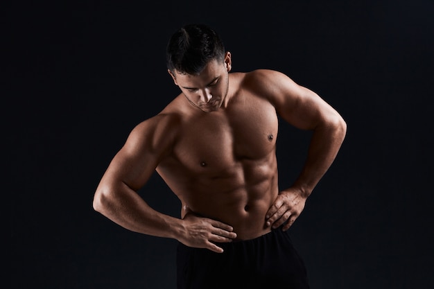 黒の筋肉ボディービルダー 強い運動男は 体 腹部の筋肉 胸の筋肉 上腕二頭筋と上腕三頭筋を示しています ワークアウト 体重を増やします ボディービル プレミアム写真
