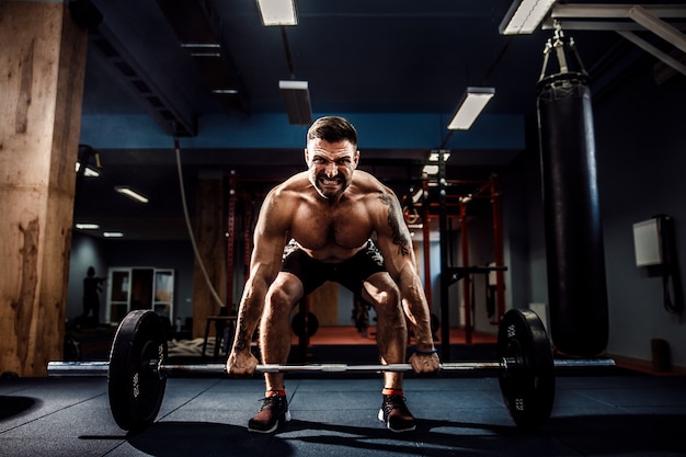 Premium Photo | Muscular fitness man doing deadlift a barbell in modern ...