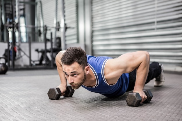 Premium Photo | Muscular man doing push up with dumbbells at the ...