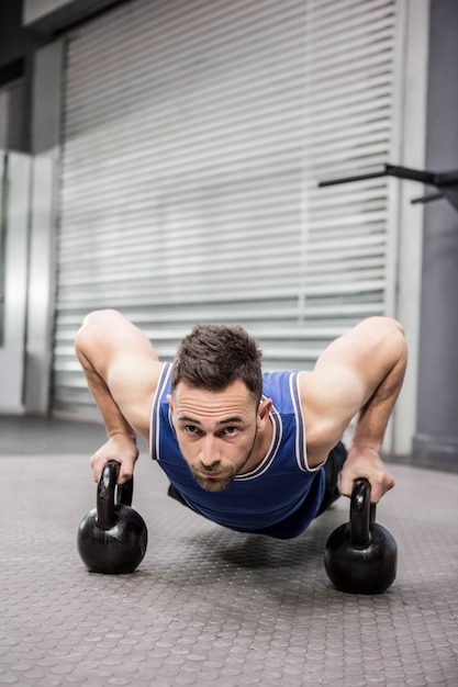 Premium Photo Muscular Man Doing Push Up With Kettlebells At The