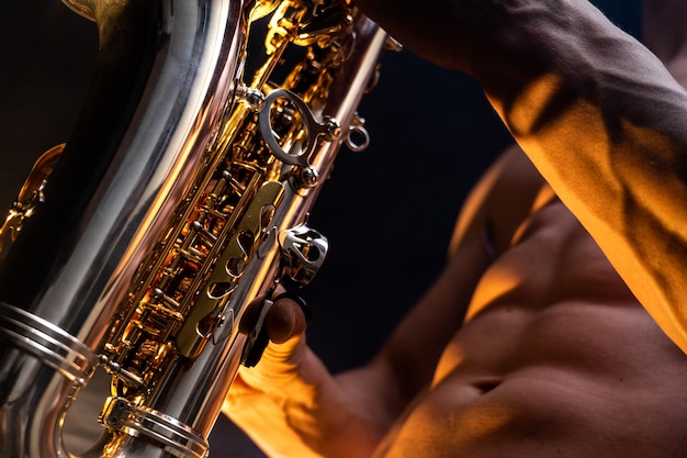 Premium Photo Muscular Man Naked Torso Playing On Saxophone With