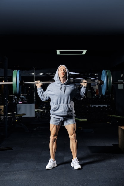 Premium Photo Muscular Man Training Squats With Barbell In Gym