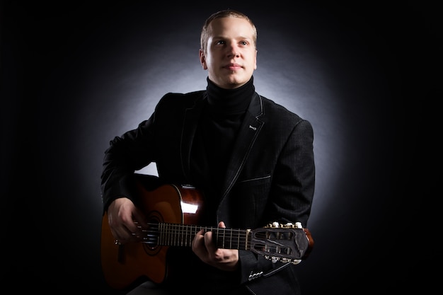音楽 ギターを抱えて黒のスーツの若い音楽家 無料の写真