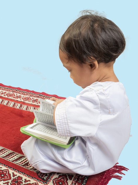 コーランを読むドレスを着たイスラム教徒の少年 プレミアム写真