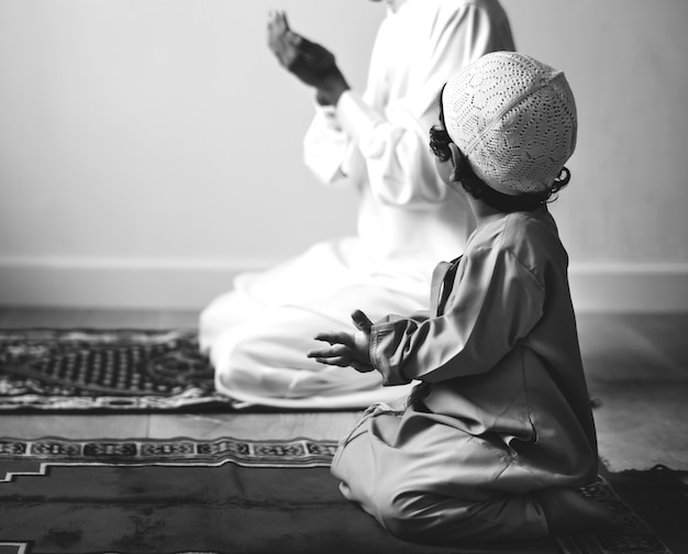 Muslim boy learning how to make dua to allah Free Photo