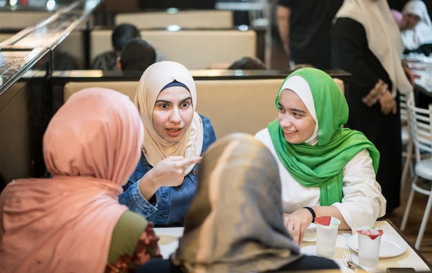 Premium Photo | Muslim girls at restaurant having iftar