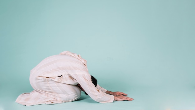 Muslim man praying on floor | Free Photo