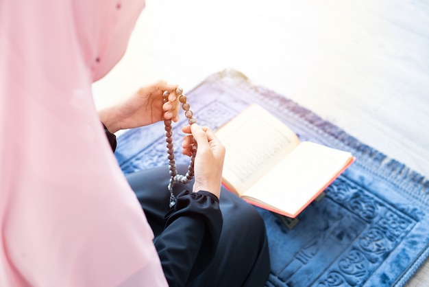 イスラム教徒の女性はビーズで祈り コーランを読む プレミアム写真