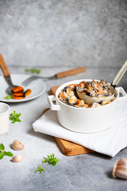 Mussels in cream and white wine sauce. served with garlic and herbs in