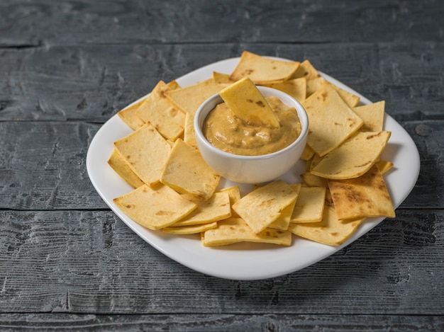 Premium Photo | Mustard with mexican tortilla chips in a white plate on ...