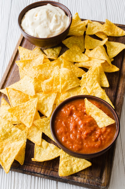 Premium Photo | Nachos corn chips with spicy tomato and cheese sauces.