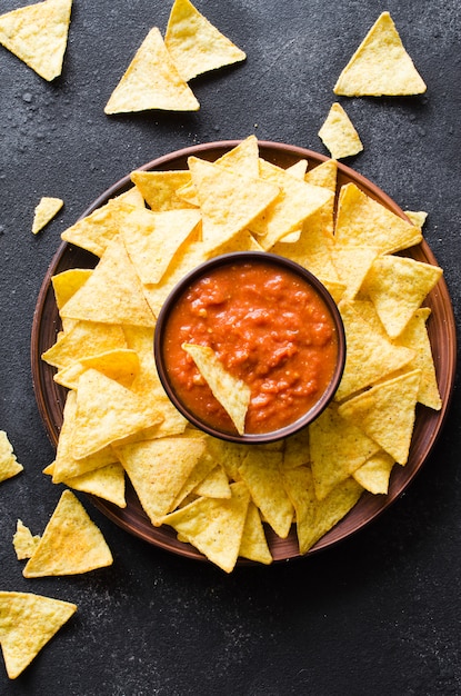 Nachos corn chips with spicy tomato sauce. | Premium Photo