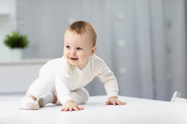 Naked baby in a white suit sitting in a bright room Premium Photo
