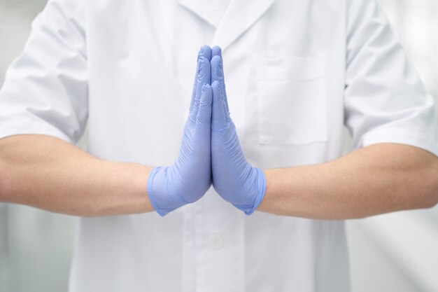 Premium Photo | Namaste gesture made by hands in medical gloves