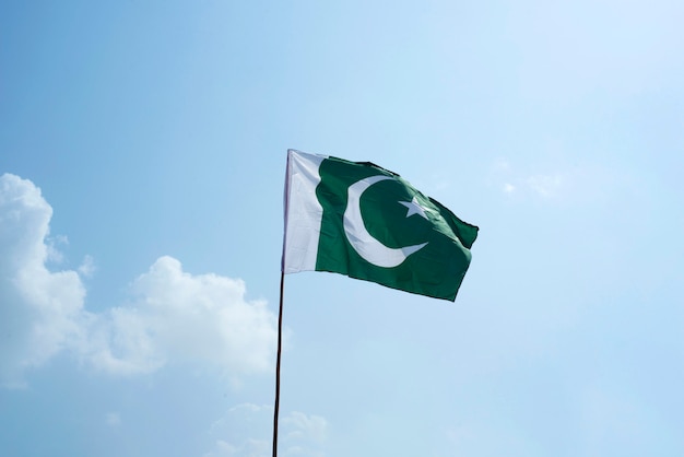 Premium Photo | The national flag of pakistan flying in the blue sky ...