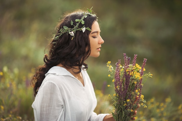 自由な楽しみの概念で屋外の花の花束を持つ自然の美しさの女の子 ポートレート写真 プレミアム写真