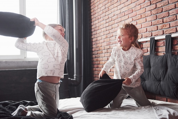 Premium Photo | Naughty children little boy and girl staged a pillow ...