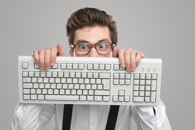 Premium Photo | Nerd in glasses with keyboard in studio