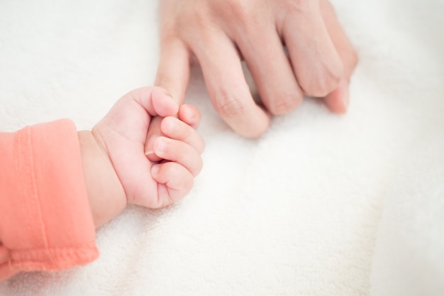 New born baby hand hold little finger of mom: concept of love, take care, parent relations Premium Photo