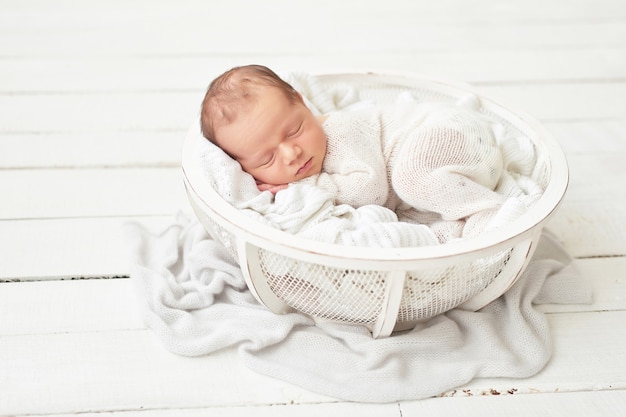 Newborn Baby Boy In A White Suit In The Crib Photo Premium Download